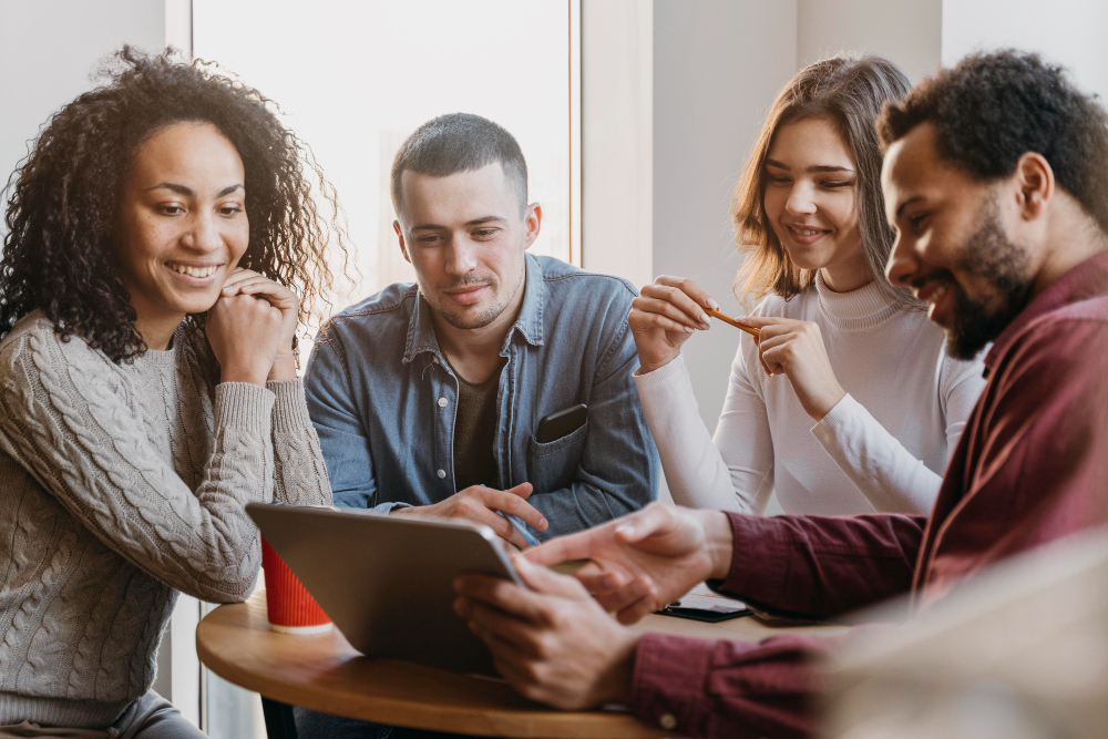 groupe de personnes devant une tablette en réunion