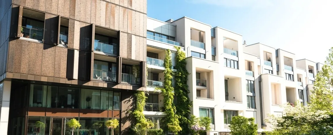 Ensemble d’immeubles d’habitation modernes, avec balcons, baies vitrées et végétation en façade