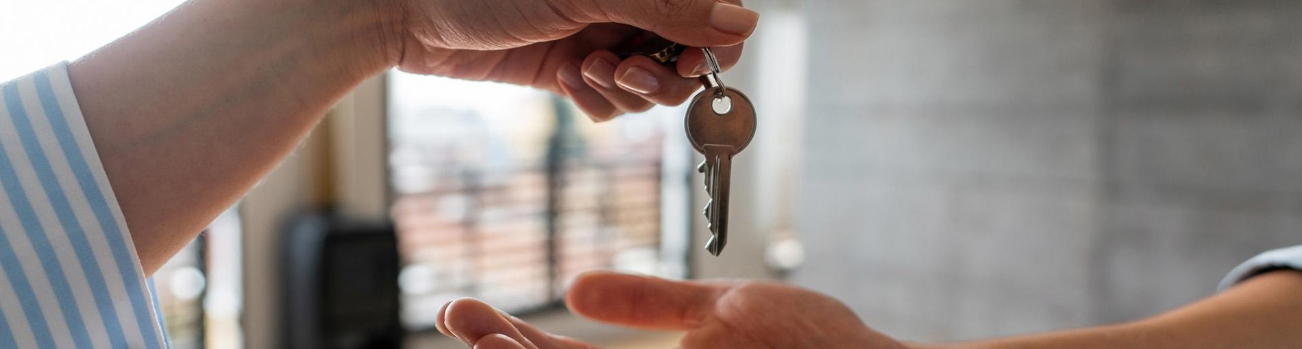 Une personne donne des clés d'un logement à une autre personne lors de l'achat immobilier