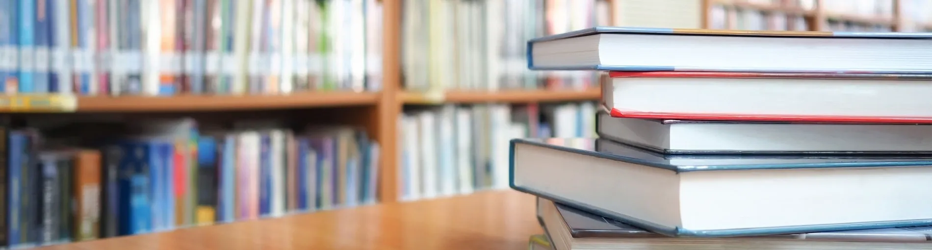 pile de livres sur un bureau dans une bibliothèque publique