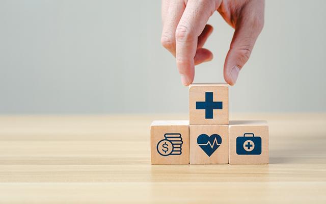 aides aux agents publics matérialisées par des carrés de bois avec les pictogrammes de pièces, coeur santé, valise et un signe plus tenu par une main