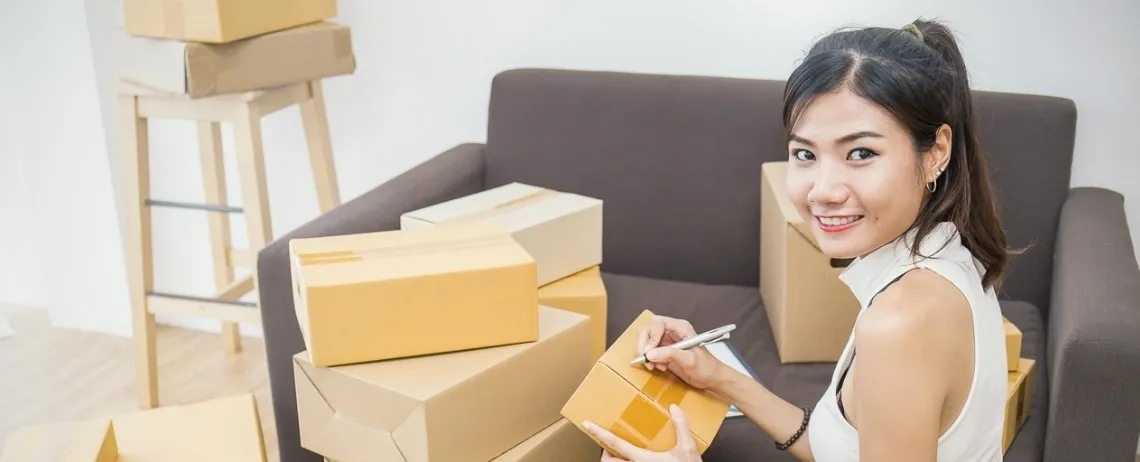 Personne préparant des colis dans un intérieur avec des cartons