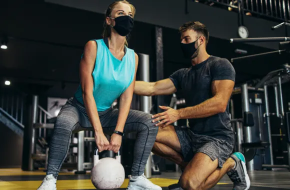 Deux personnes en séance d’entraînement en salle de sport.