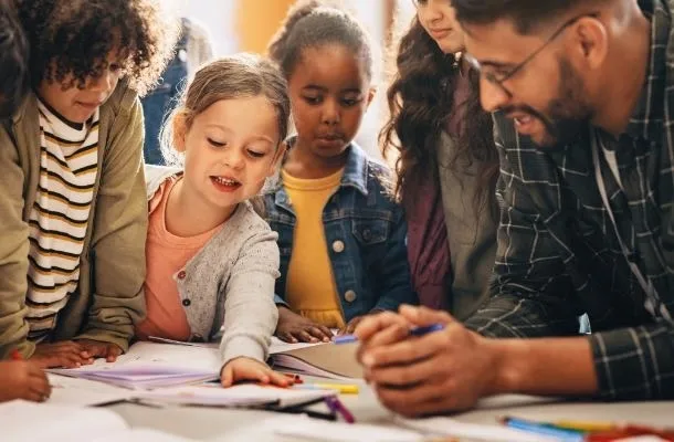jeune enseignant en école primaire avec ses élèves