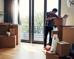 homme défaisant ses cartons dans nous nouvel appartement