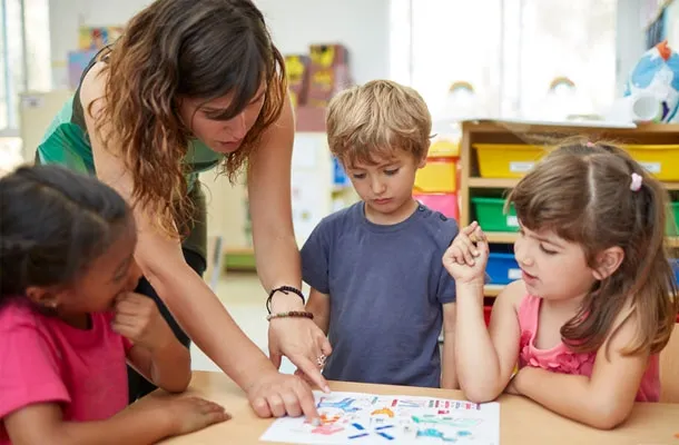 Enseignante montrant à des enfants des dessins de dinosaures