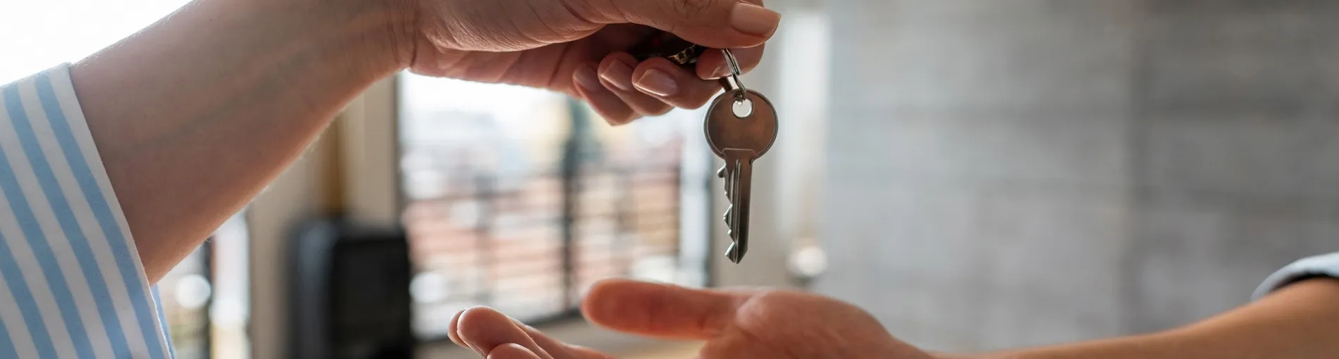 Une personne donne des clés d'un logement à une autre personne lors de l'achat immobilier