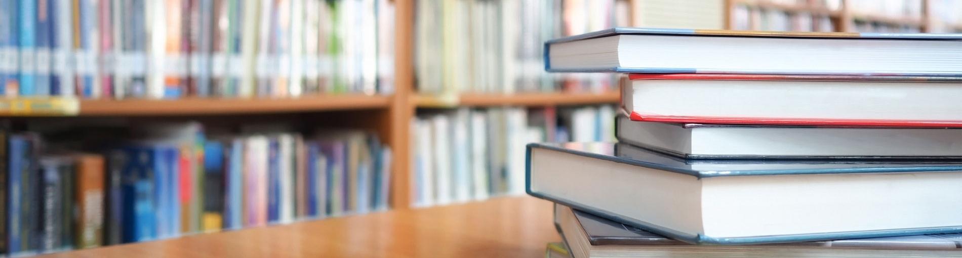 pile de livres sur un bureau dans une bibliothèque publique