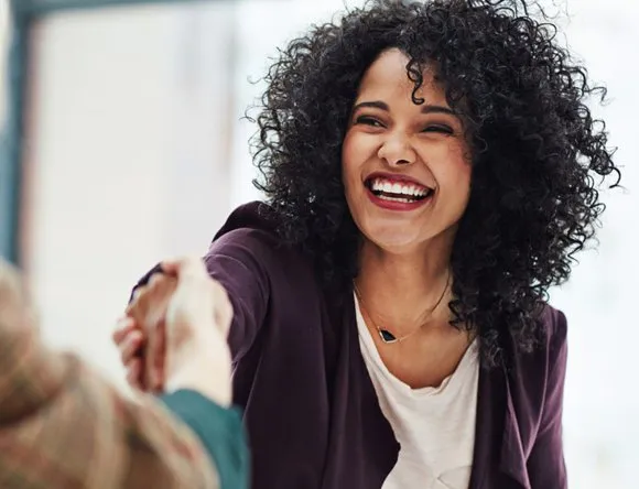 une jeune femme sert la main de son employeur