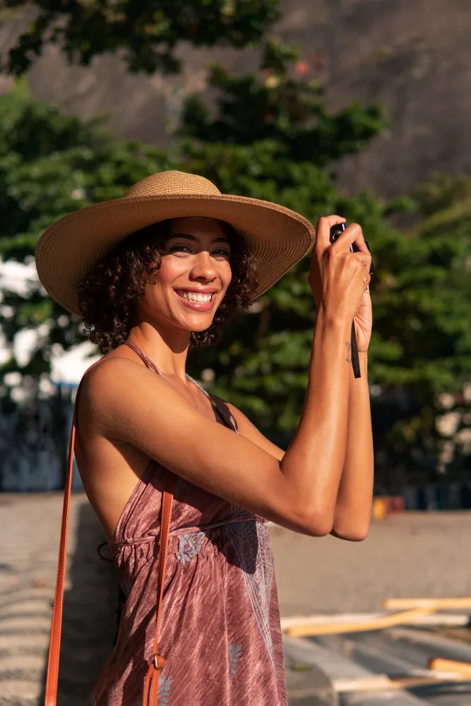 femme avec un chapeau et un appareil photo
