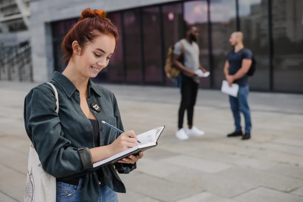 Etudiante qui prend des notes sur un cahier