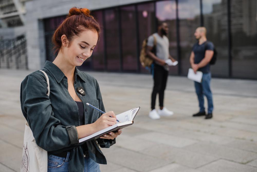 Etudiante qui prend des notes sur un cahier