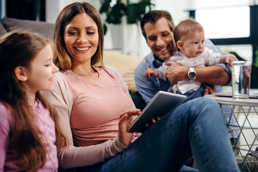 parent avec deux enfants devant une tablette
