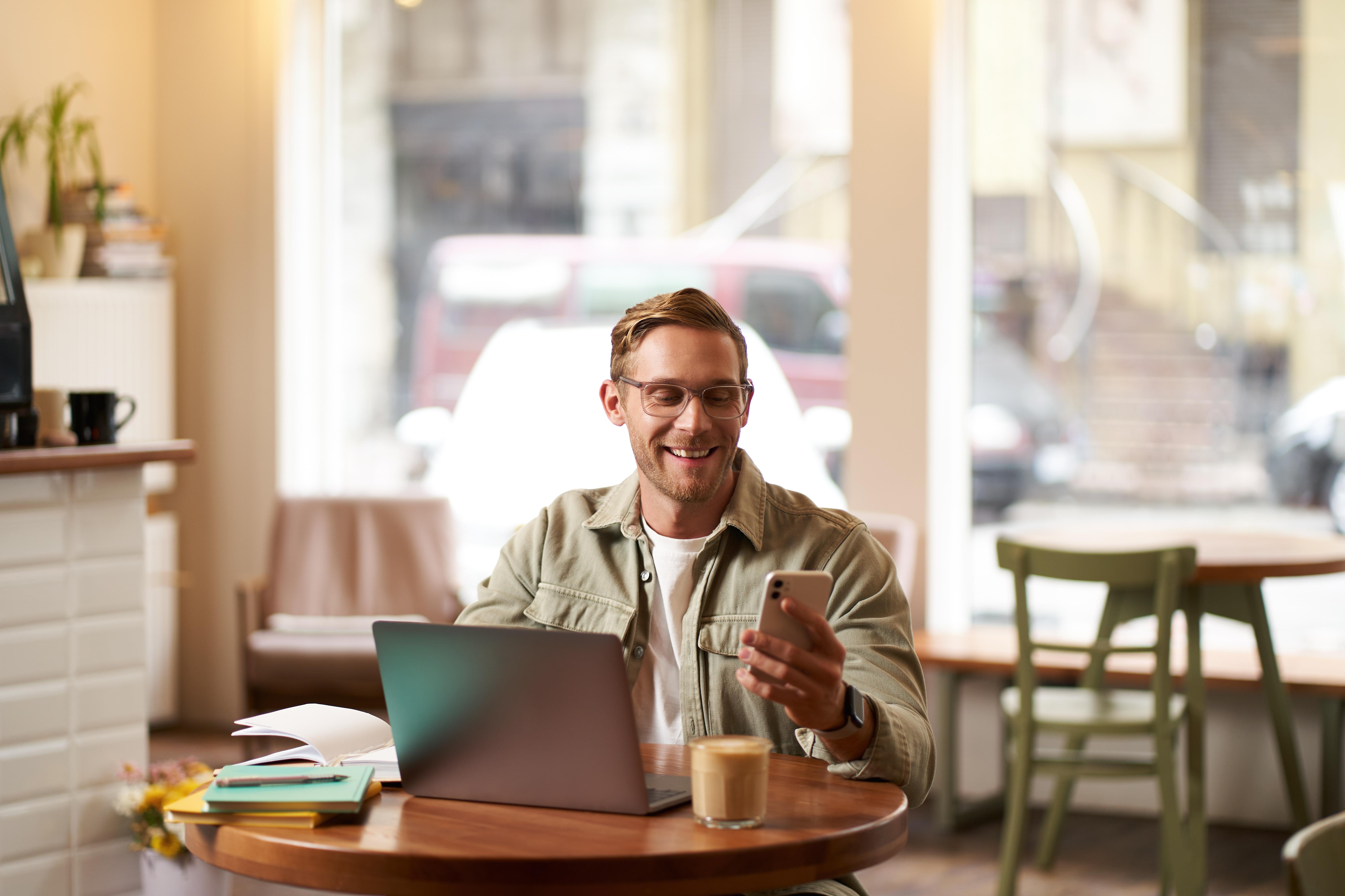 jeune homme dans un bar devant un ordinateur
